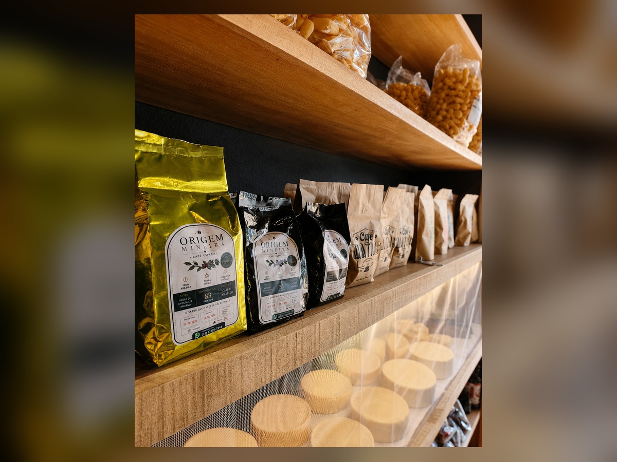 Pacotes de cafés especiais mineiros na prateleira de madeira do empório